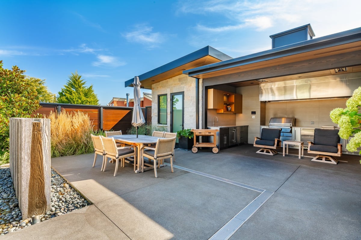 Modern home exterior with expansive deck, outdoor living area and glass doors