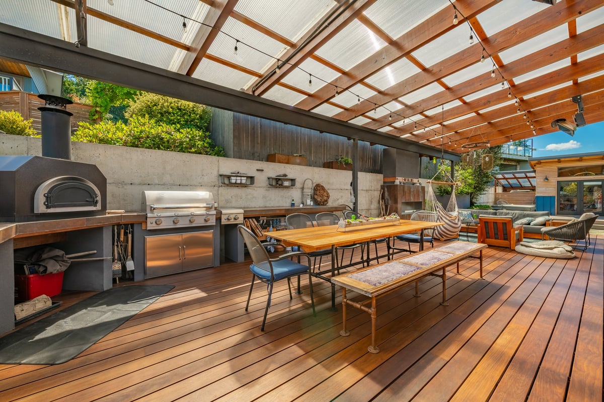 Covered patio with slatted wood roof, full outdoor kitchen, dining and lounge areas
